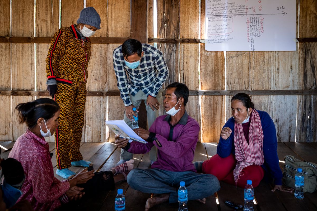 Community Forest Chief Ton Mean shows documents in a discussion with RECOFTC's provincial coordinator during the COVID-19 survey, in Samaky Trapang Totim, Romtom Commune, Rovieng District, Preah Vihear Province.