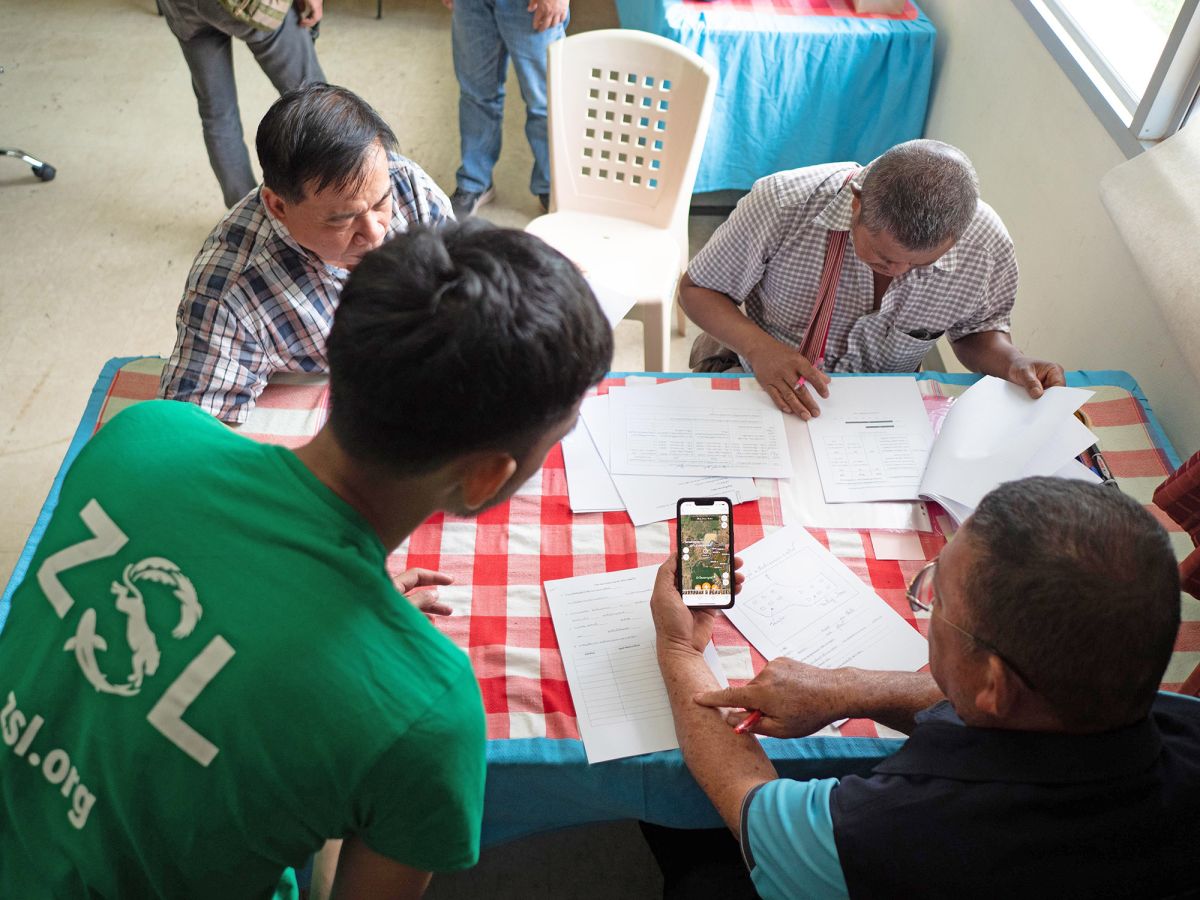 RECOFTC and ZSL staff guiding CF Masters on using a mobile application for conducting forest inventories.