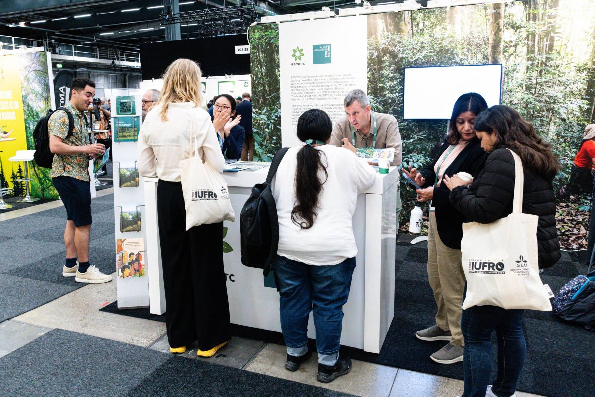 RECOFTC and WYSS Academy staff respond to visitor queries at the exhibit.