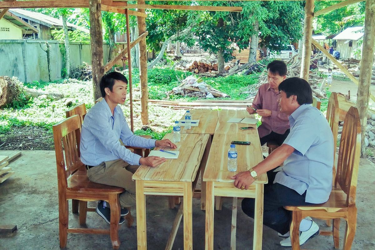 Field coordinator Chay Senkhammoungkhoun, discusses teak prices with  teak trader in Natornai  village, Xaiyaboury  Province.