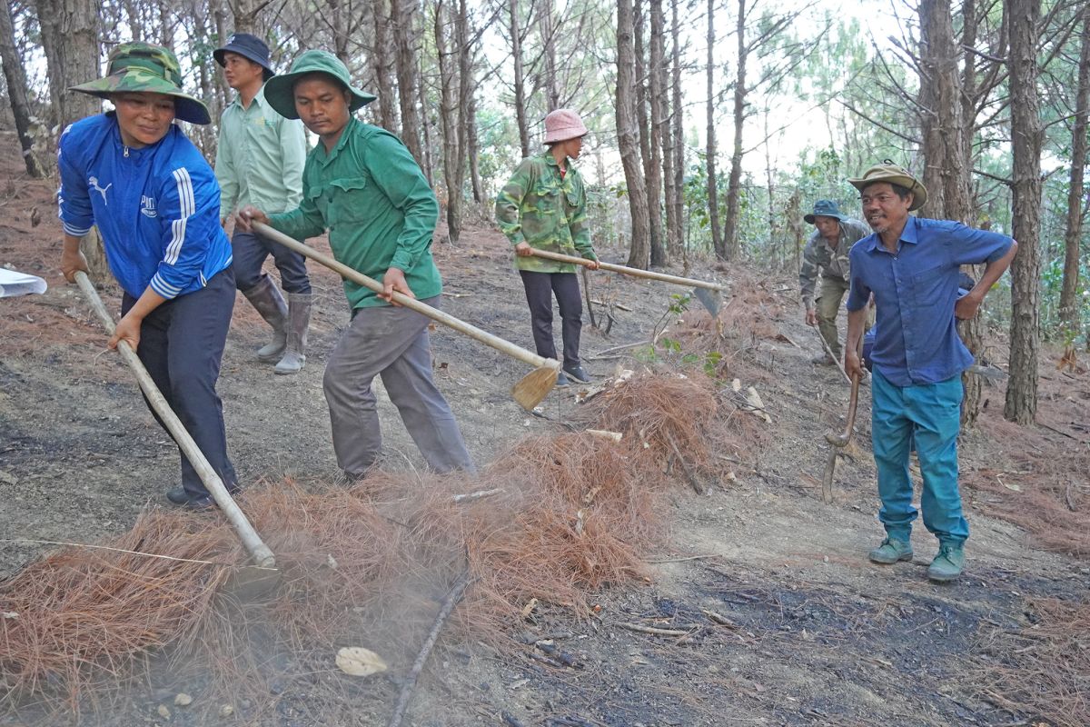 Women and men in Tan Ha village participate in a demonstration on constructing a firebreak line.