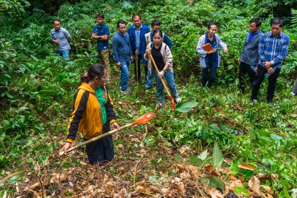 Participants at the ToT workshop work with community members to clear the underbrush to create fire breaks in the nearby forest in Namyonemai village, Bokeo Province, Lao PDR. Photo by RECOFTC